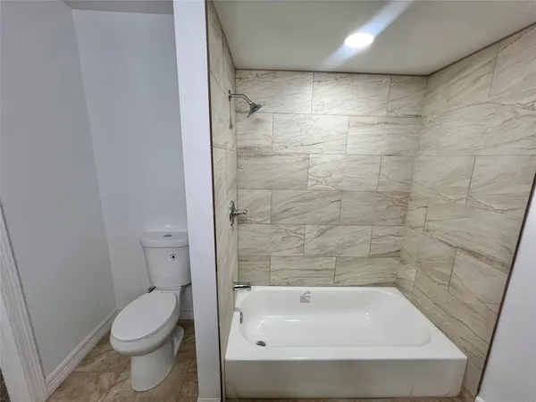 a bathroom with a bathtub and a toilet