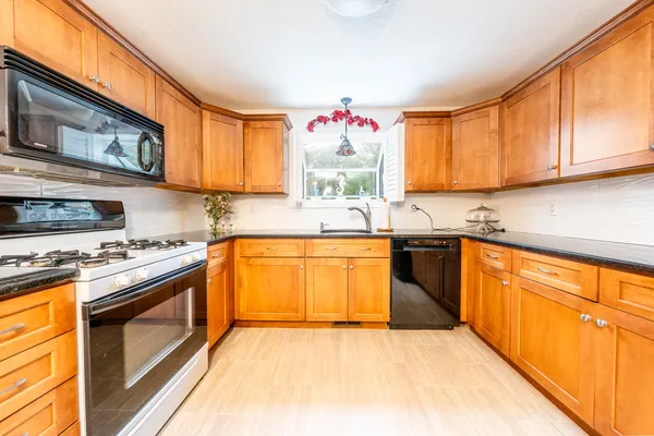a kitchen with stainless steel appliances granite countertop a stove a sink and a microwave