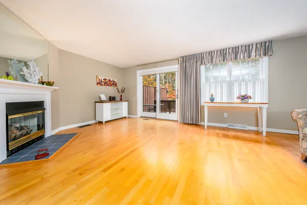 a view of an empty room with a fireplace and a window