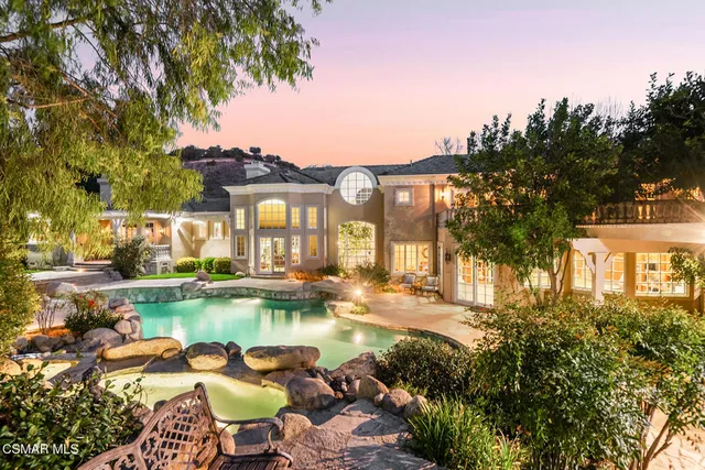 a front view of a building with garden and flowers