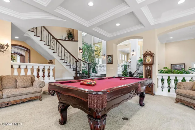 a spacious bedroom with a bed a chandelier and large window