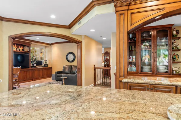 a bedroom with a large bed and a chandelier fan