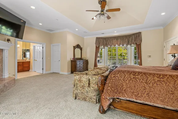 a bedroom with a bed and a large window with outer view