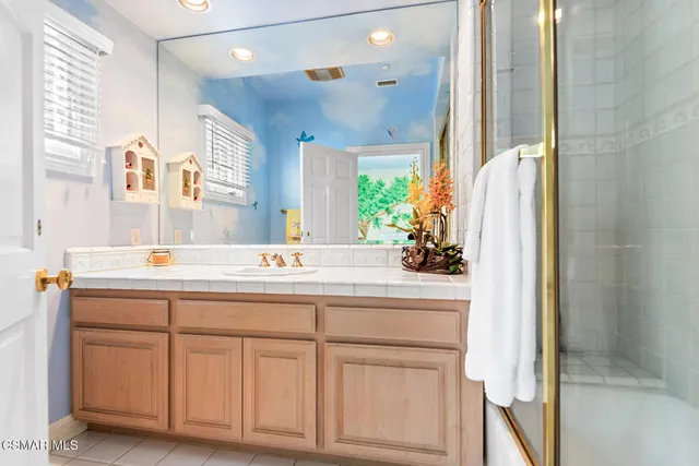 a front view of a house with a yard and large tree