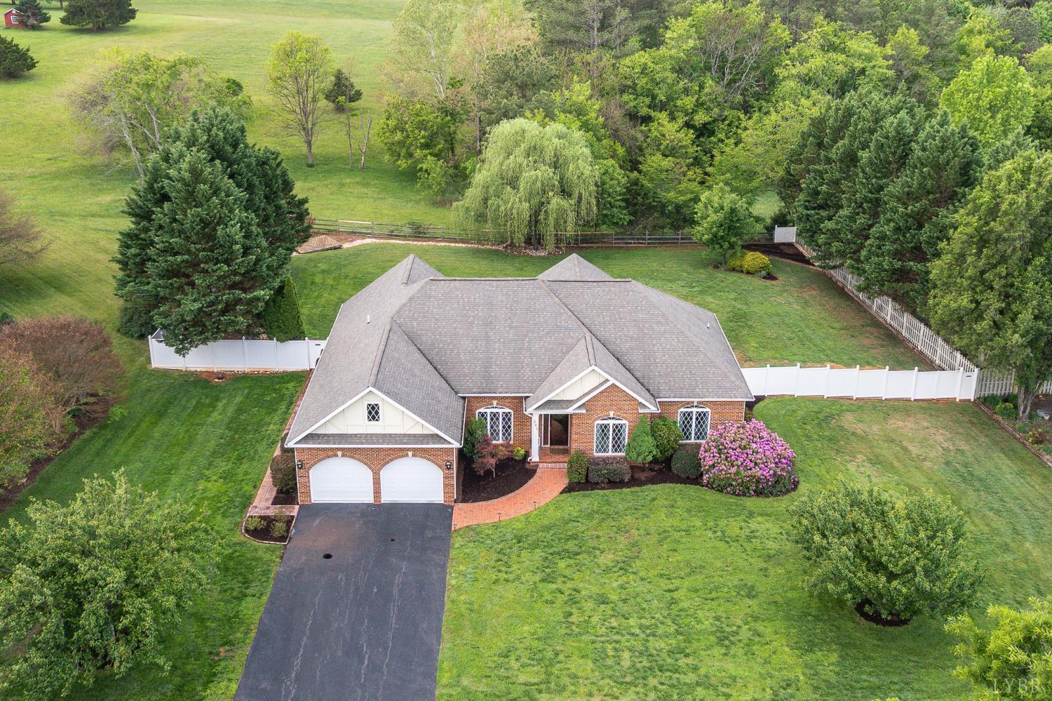 an aerial view of residential houses with outdoor space and trees