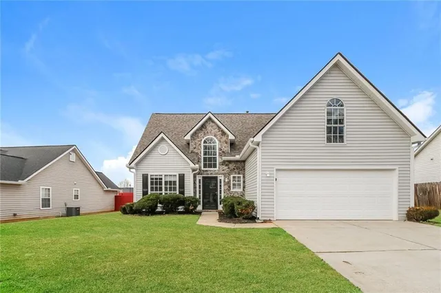 a front view of a house with a yard and garage