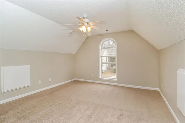 an empty room with windows and chandelier fan