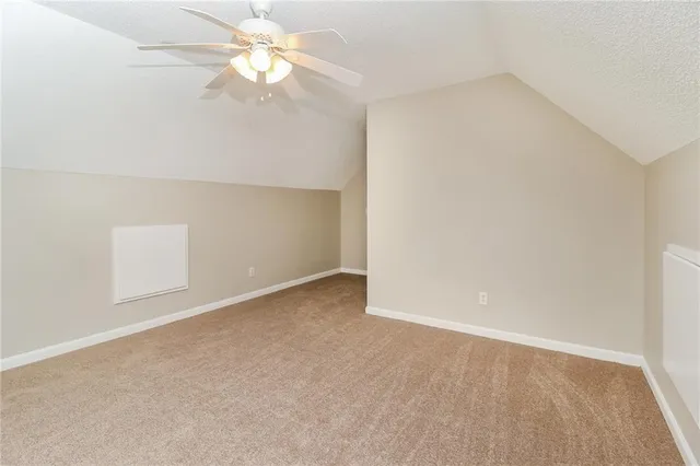 an empty room with a chandelier fan and closet