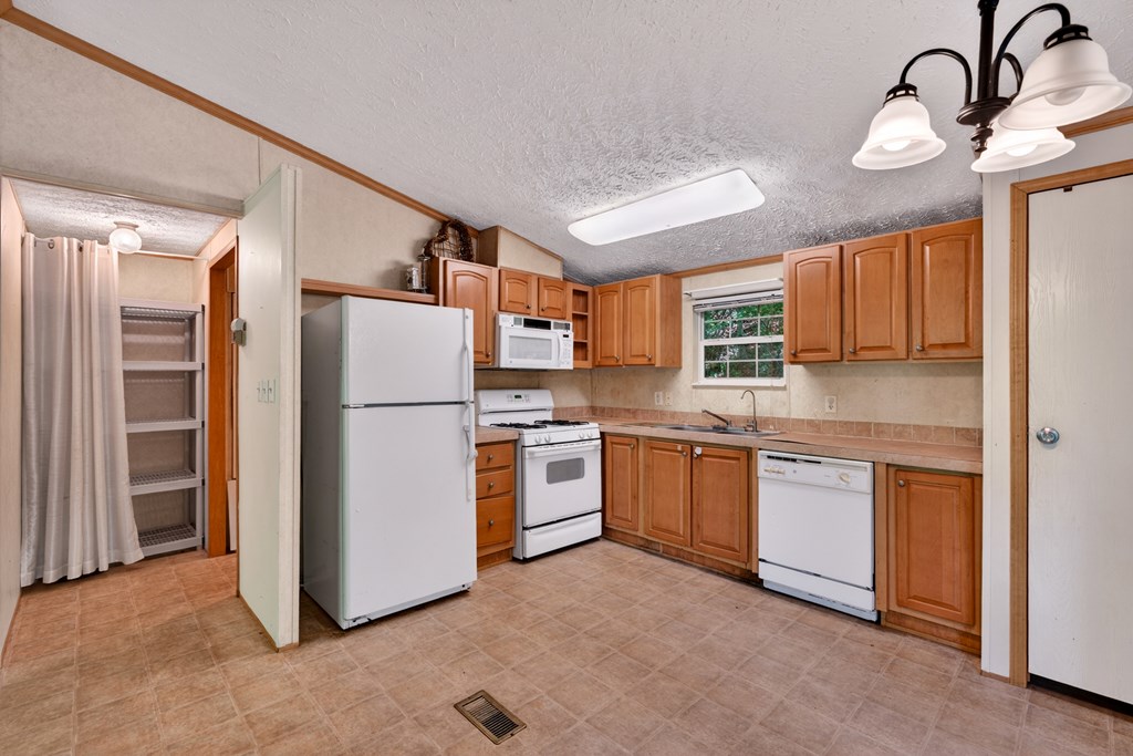 282 West Cherry Road Hayesville, NC 28904 - Photo 5 of 45 a kitchen with stainless steel appliances granite countertop a refrigerator a stove top oven a sink and dishwasher