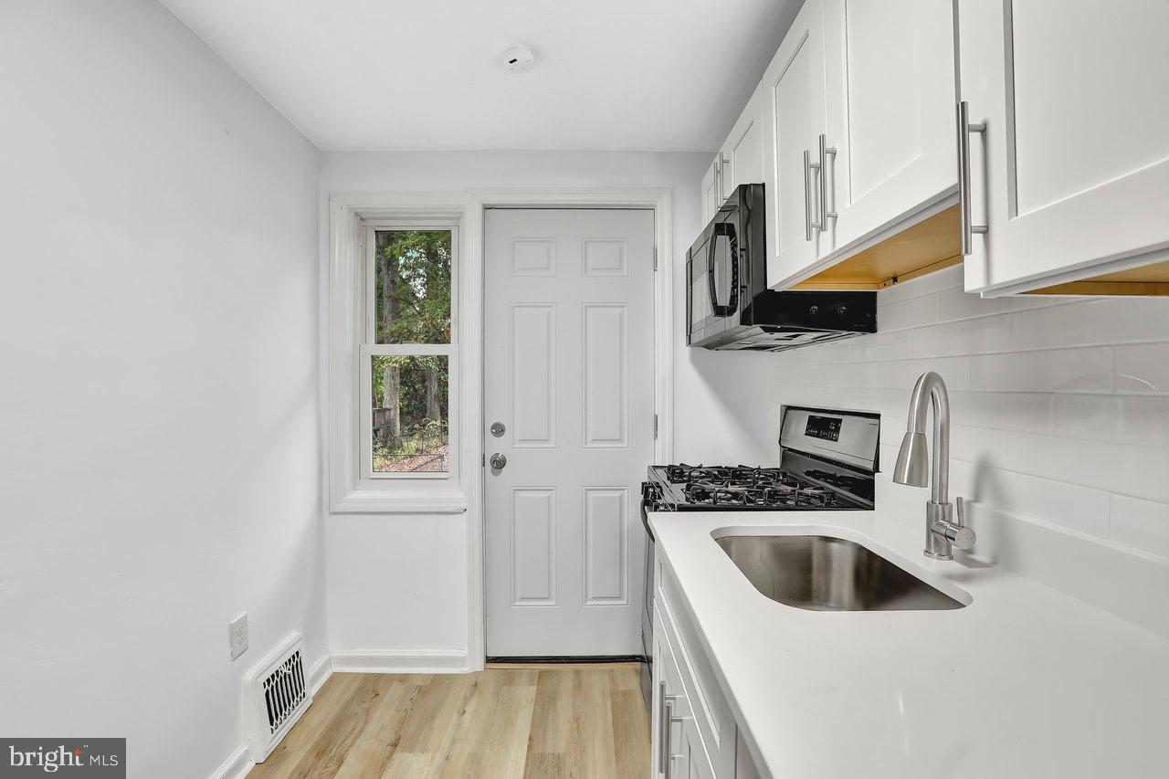 331 Oakland Street Ewing, NJ 08618 - Photo 8 of 21 a kitchen with a sink a stove and cabinets
