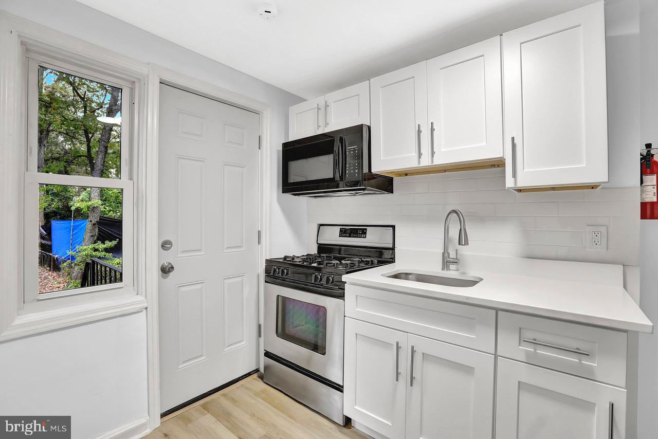 331 Oakland Street Ewing, NJ 08618 - Photo 9 of 21 a kitchen with white cabinets and a stove top oven