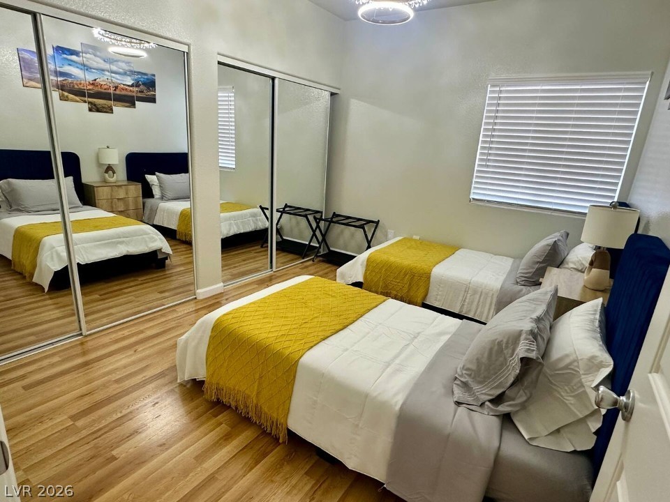 9580 West Reno Avenue, Unit 169 Las Vegas, NV 89148 - Photo 12 of 15 Well-lit sleeping quarters with rich hardwood flooring and a mirror-clad closet.