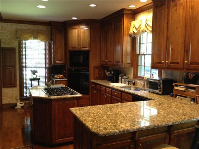 3301 Wimbledon Road Nashville, TN 37215 - Photo 7 of 9 Kitchen is warm and inviting with rich wood tones, hardwood floors, bay window in the breakfast area, built-in cabinets, gas log fireplace, granite and ss appliances.