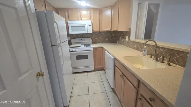 a kitchen with a sink a refrigerator a washer and dryer