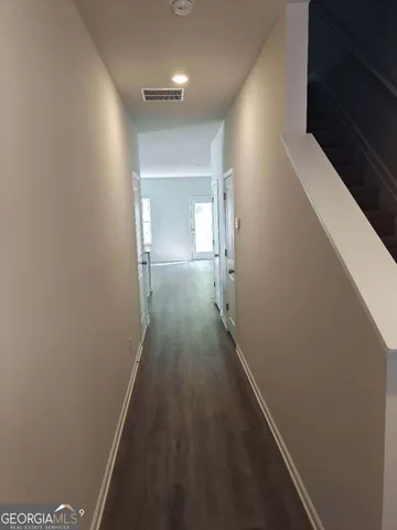 a view of a hallway with wooden floor