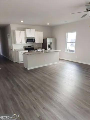 a view of kitchen with sink microwave refrigerator and cabinets
