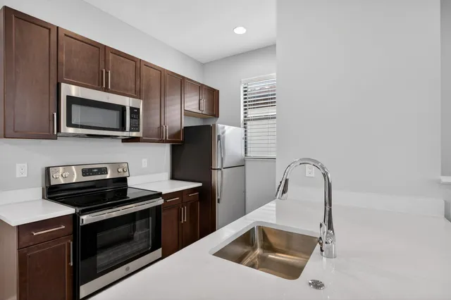 a kitchen with a sink stove and microwave