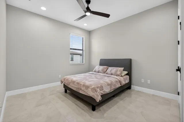 a bed sitting in a bedroom next to a window and a chandelier