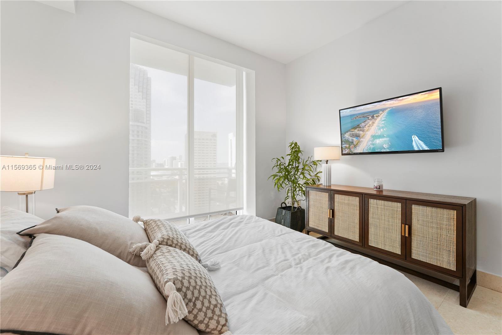 901 Brickell Key Boulevard, Unit 3504 Miami, FL 33131 - Photo 20 of 44 a bedroom with a bed and a window
