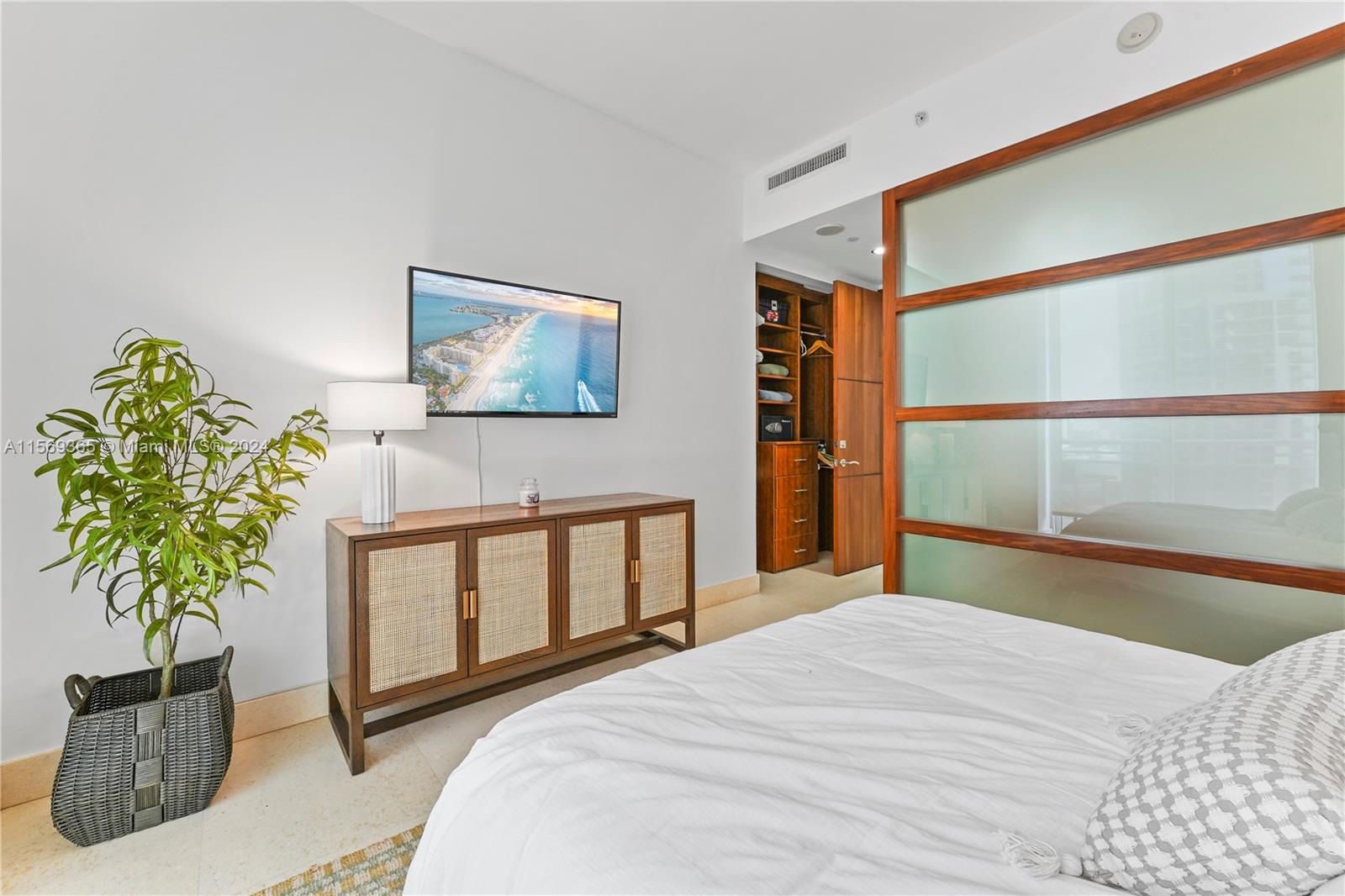 901 Brickell Key Boulevard, Unit 3504 Miami, FL 33131 - Photo 21 of 44 a bedroom with a bed and a potted plant