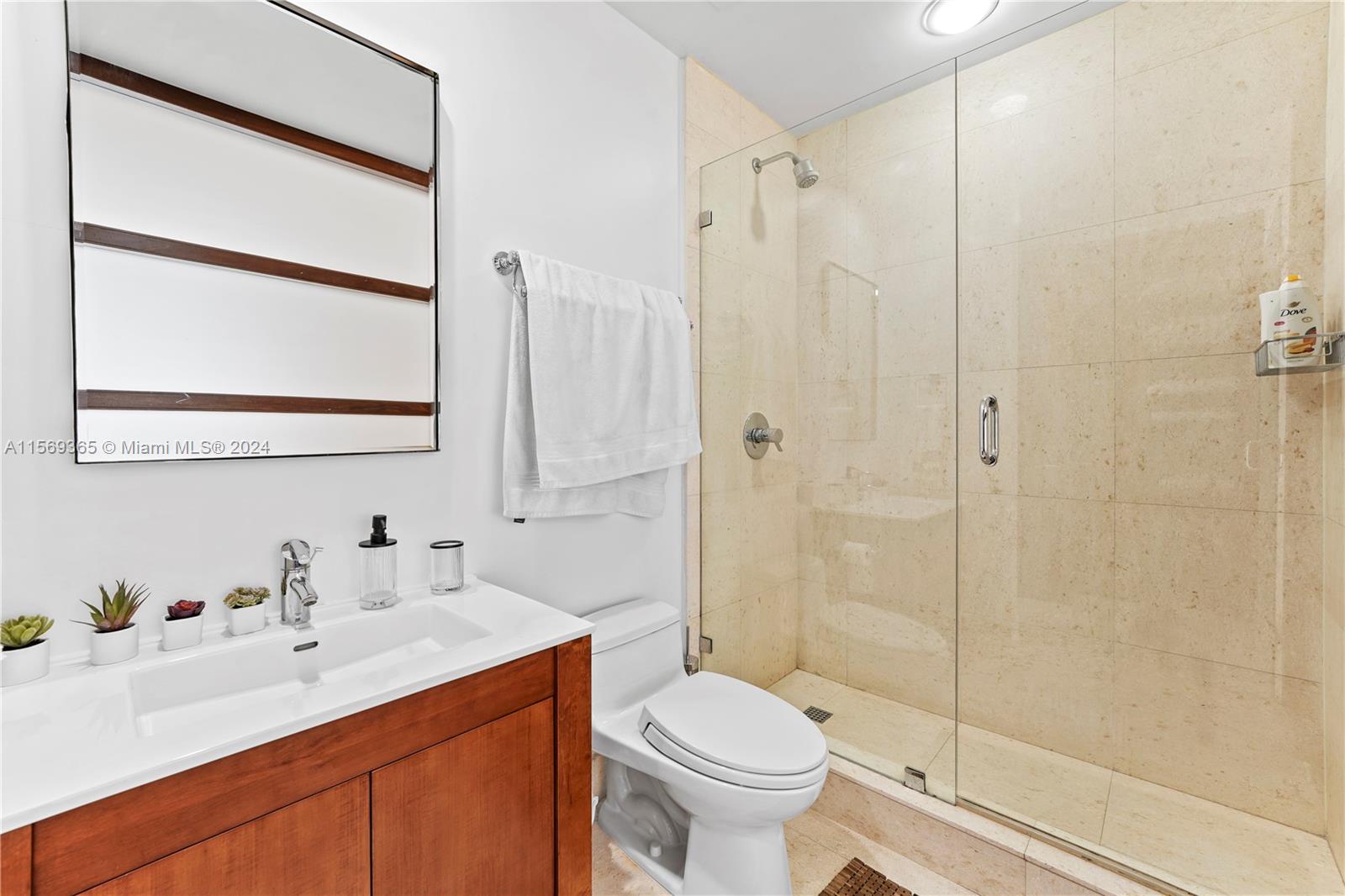901 Brickell Key Boulevard, Unit 3504 Miami, FL 33131 - Photo 22 of 44 a bathroom with a sink toilet a mirror and shower