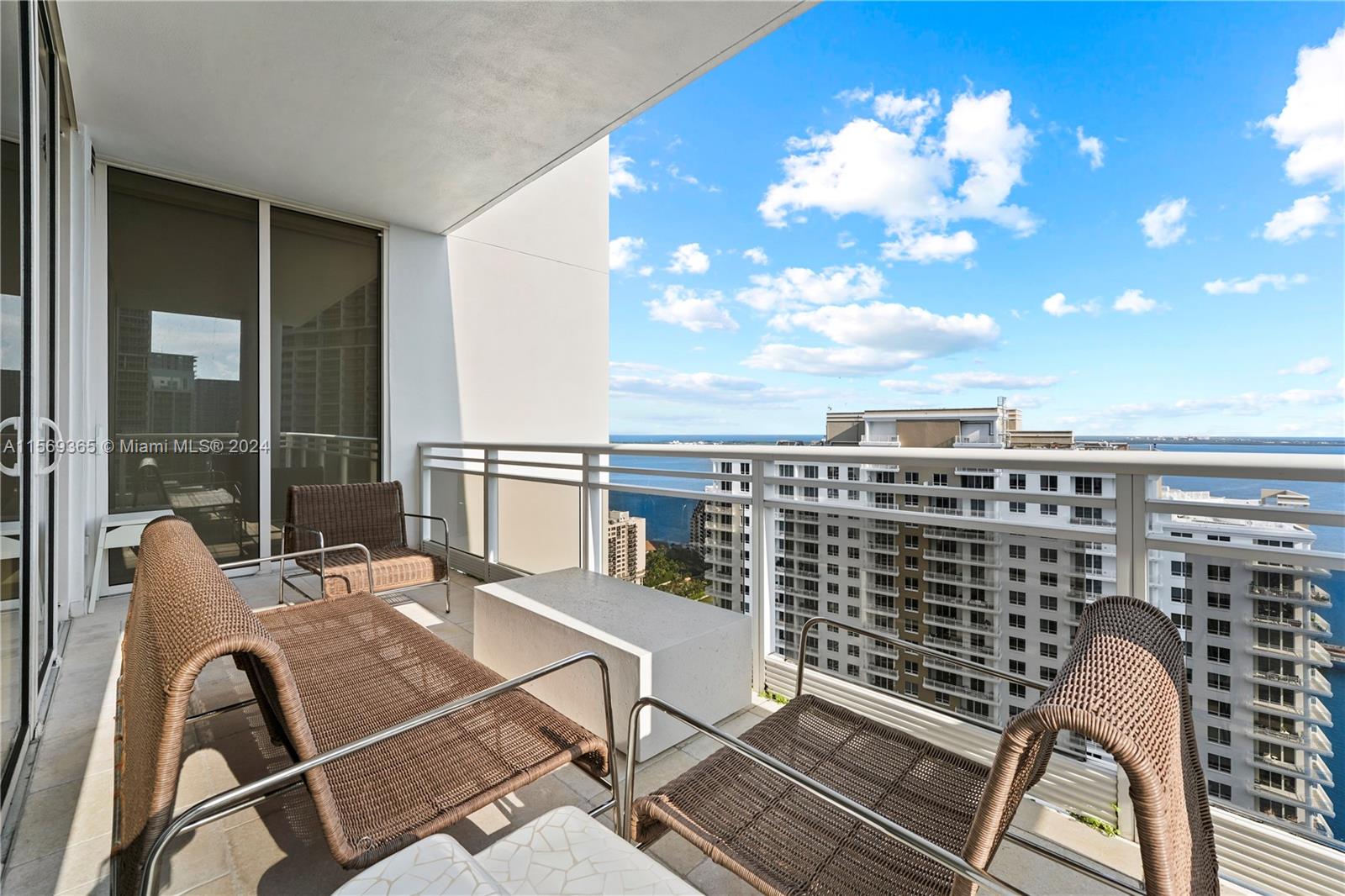 901 Brickell Key Boulevard, Unit 3504 Miami, FL 33131 - Photo 32 of 44 a view of a balcony with two chairs and a potted plant
