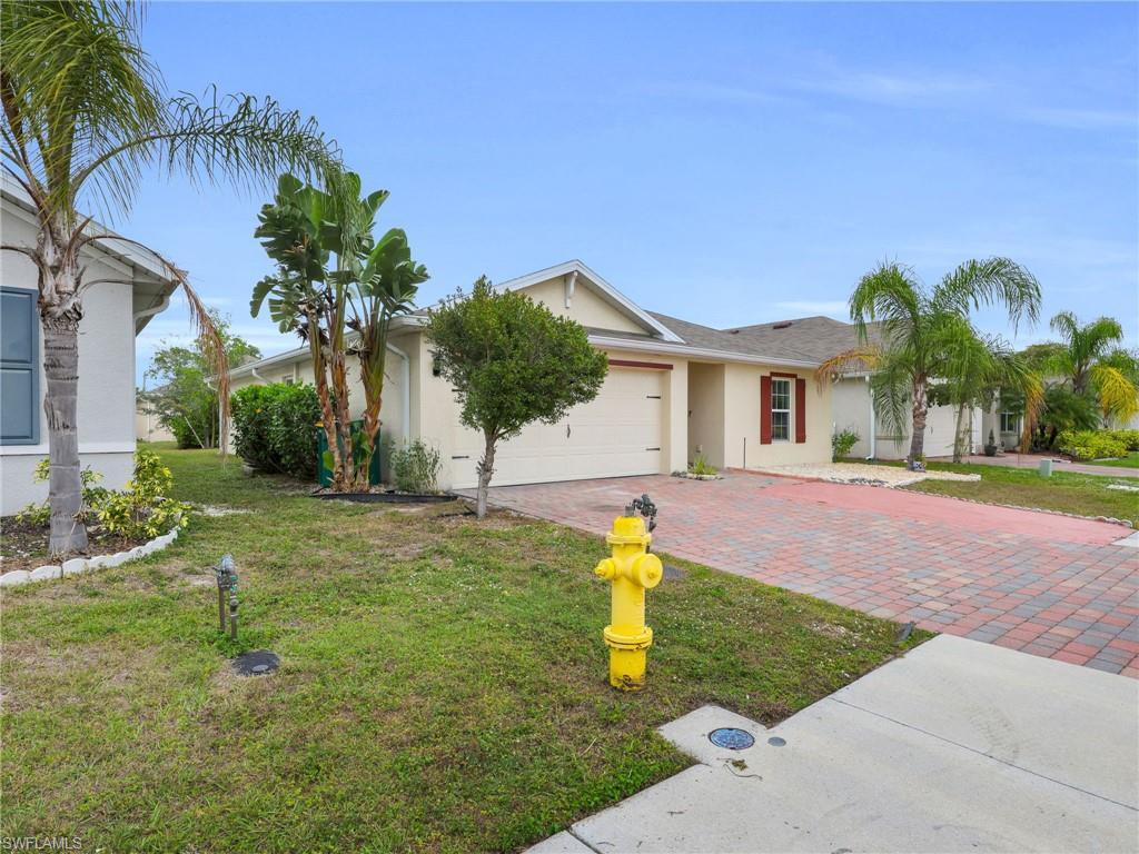 731 Hadley Place West Naples, FL 34104 - Photo 26 of 30 Front Angled View of 731 Hadley Place W With Left Side Yard View And Widened Driveway