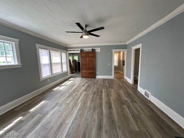 1388 Brookline Road Cleveland, OH 44121 - Photo 4 of 30 Unfurnished living room featuring a barn door, ceiling fan, ornamental molding, and dark wood-type flooring