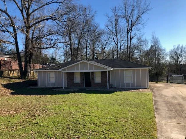 a front view of a house with yard and trees