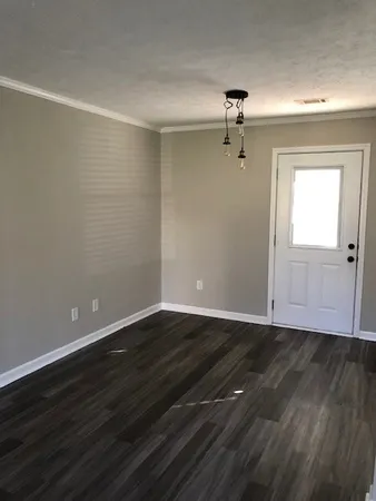 a view of a room with wooden floor ceiling fan and window