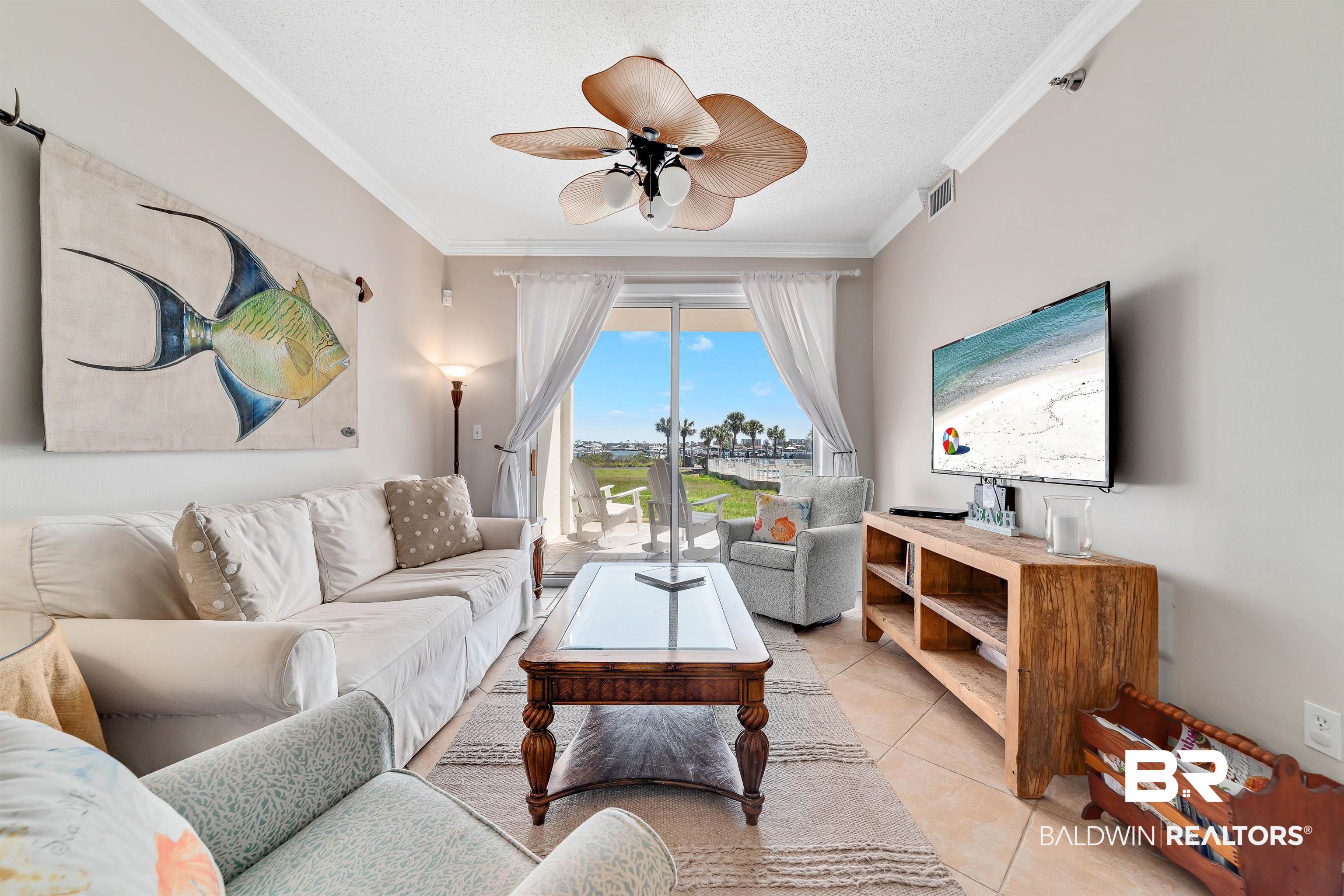 27282 Canal Road, Unit 110 Orange Beach, AL 36561 - Photo 14 of 62 Living room with light tile patterned floors, ceiling fan, visible vents, and ornamental molding
