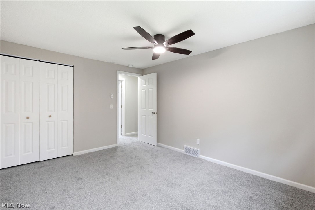 7012 Roe Boulevard Madison, OH 44057 - Photo 20 of 30 Light gray carpeting throughout, featuring a dark-toned ceiling fan with integrated lighting