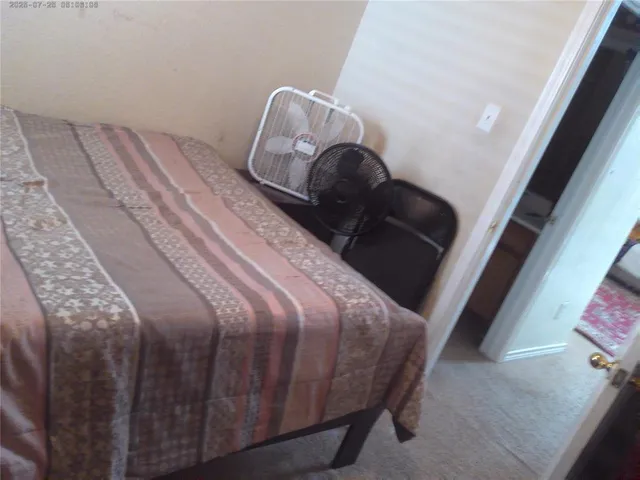 a bed sitting in a bedroom next to a window