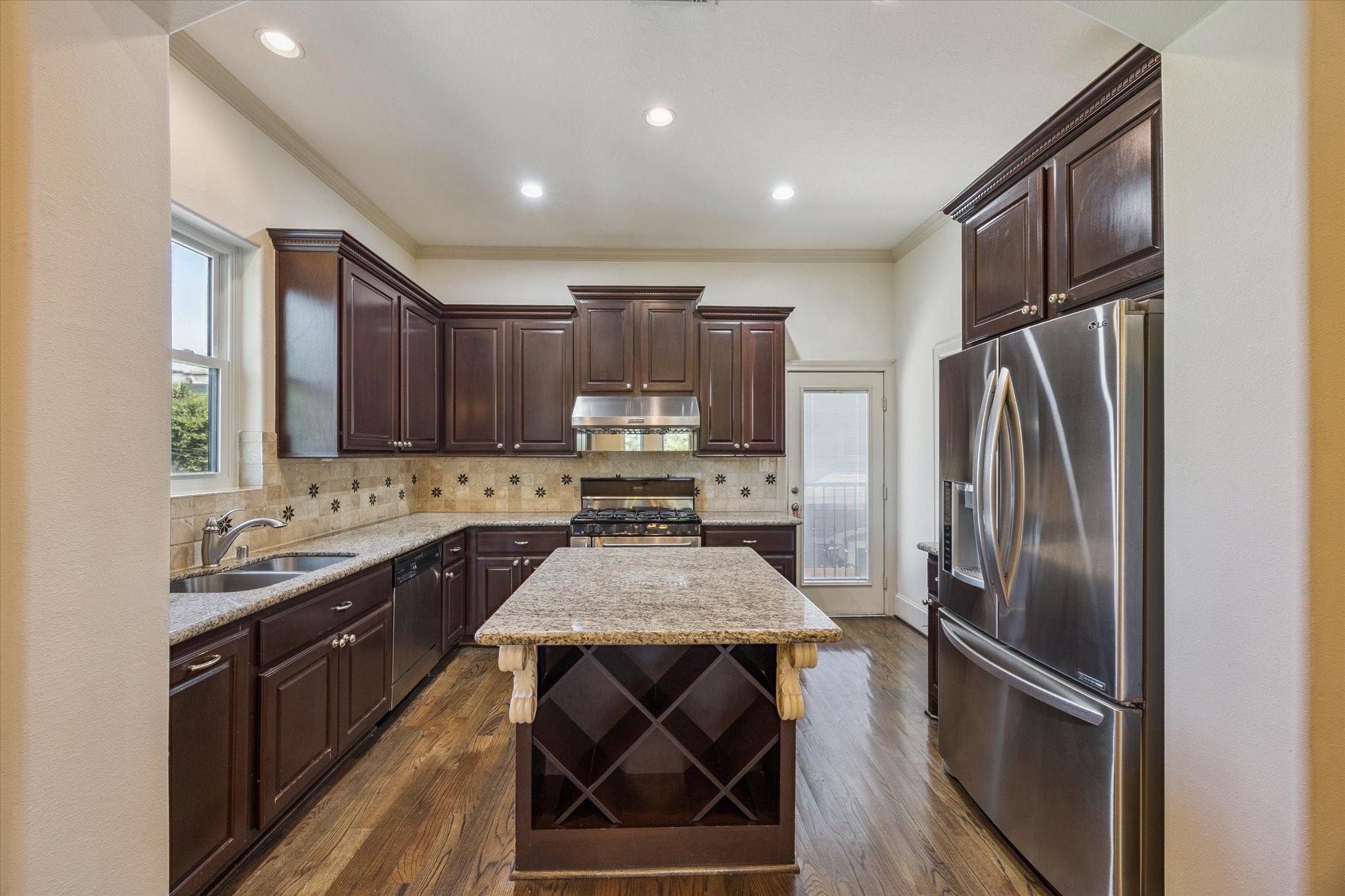 2803 Chartres Street Houston, TX 77004 - Photo 7 of 22 a kitchen with kitchen island granite countertop stainless steel appliances a sink stove refrigerator and cabinets