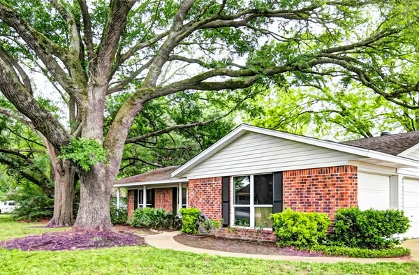 a view of a house with a yard and potted plants