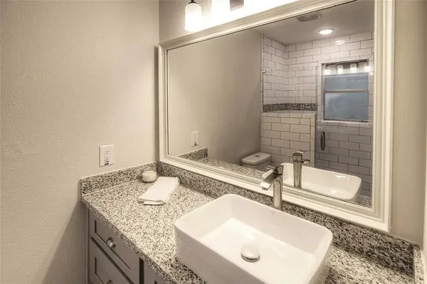 a bathroom with a granite countertop sink and a mirror
