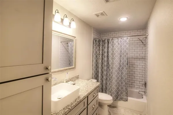 a bathroom with a granite countertop sink toilet and shower