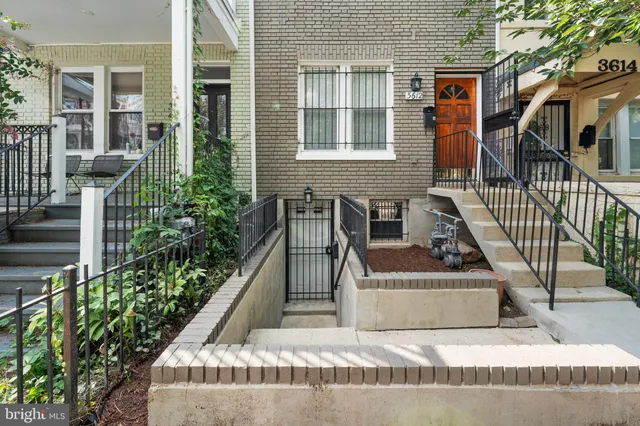 front view of house with a bench and potted plants