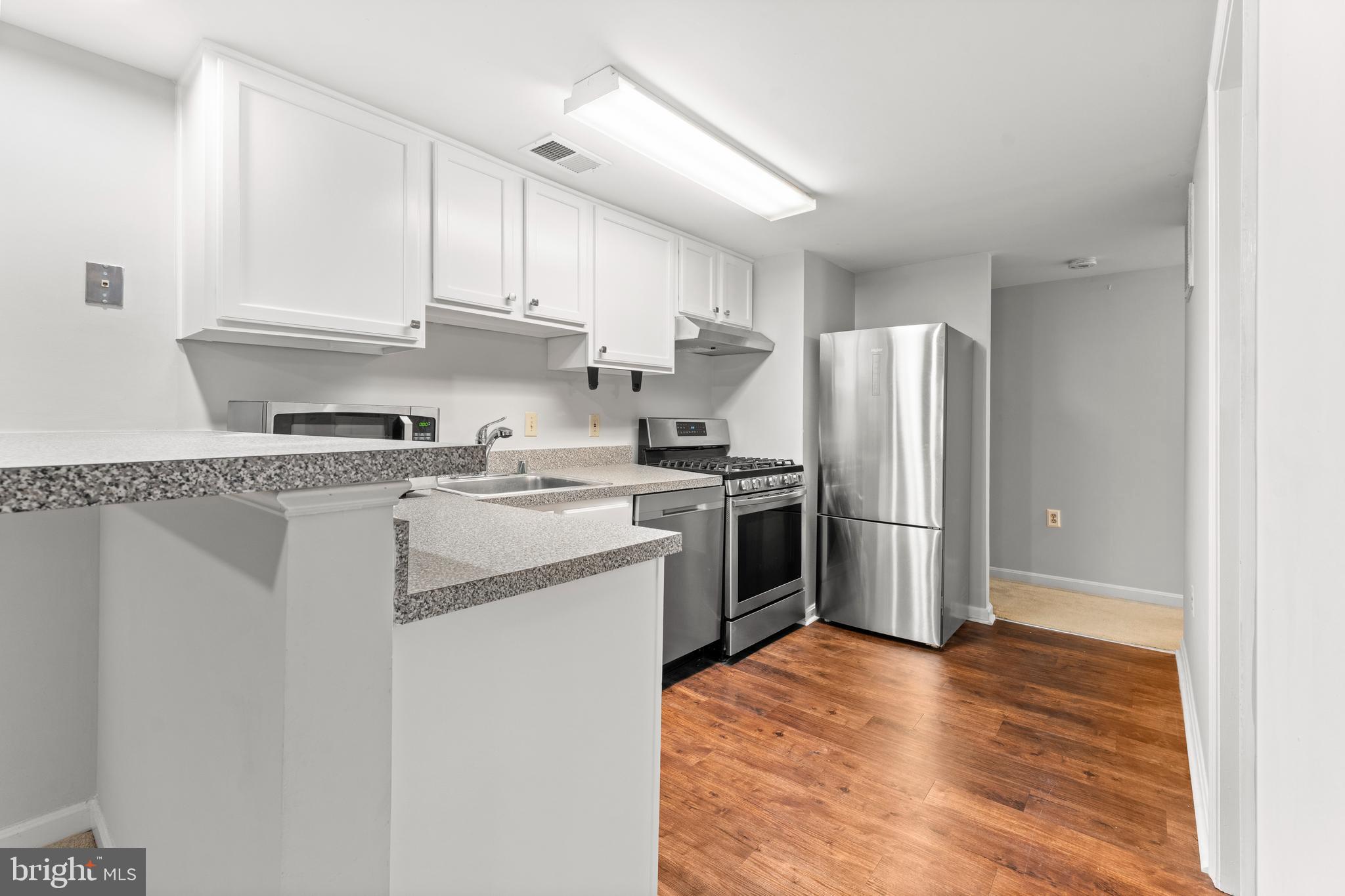 3612 Rock Creek Church Road Northwest, Unit LWR Washington, DC 20010 - Photo 13 of 19 a kitchen with a refrigerator sink and cabinets