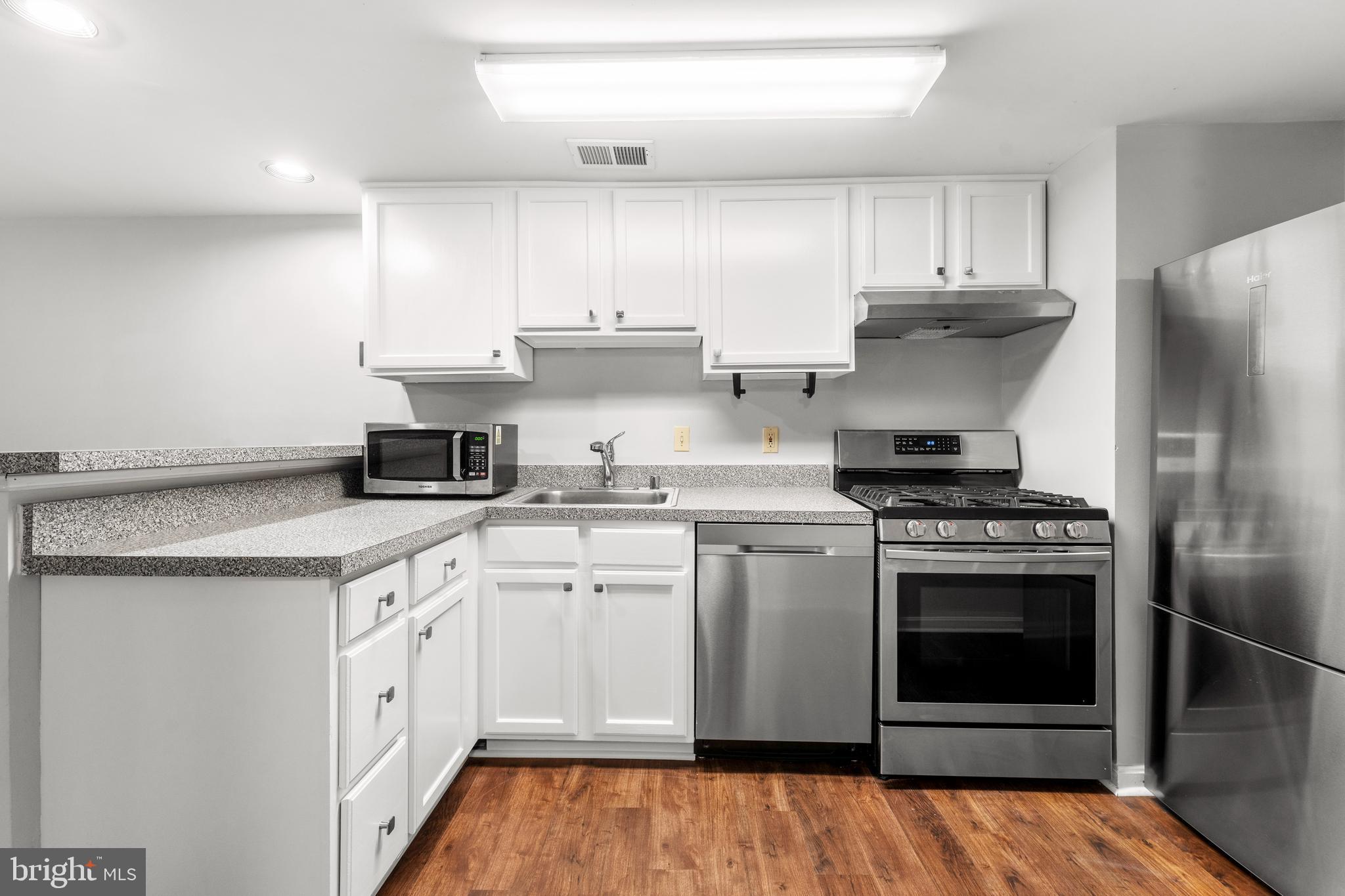 3612 Rock Creek Church Road Northwest, Unit LWR Washington, DC 20010 - Photo 6 of 19 a kitchen with stainless steel appliances granite countertop a stove a sink and a refrigerator