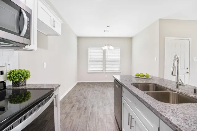 a kitchen with a granite countertop sink and window