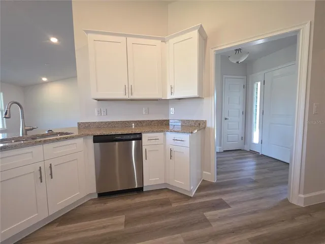 a kitchen with a sink cabinets and wooden floor