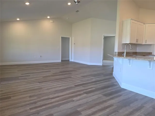 a view of a kitchen with wooden floor and a sink