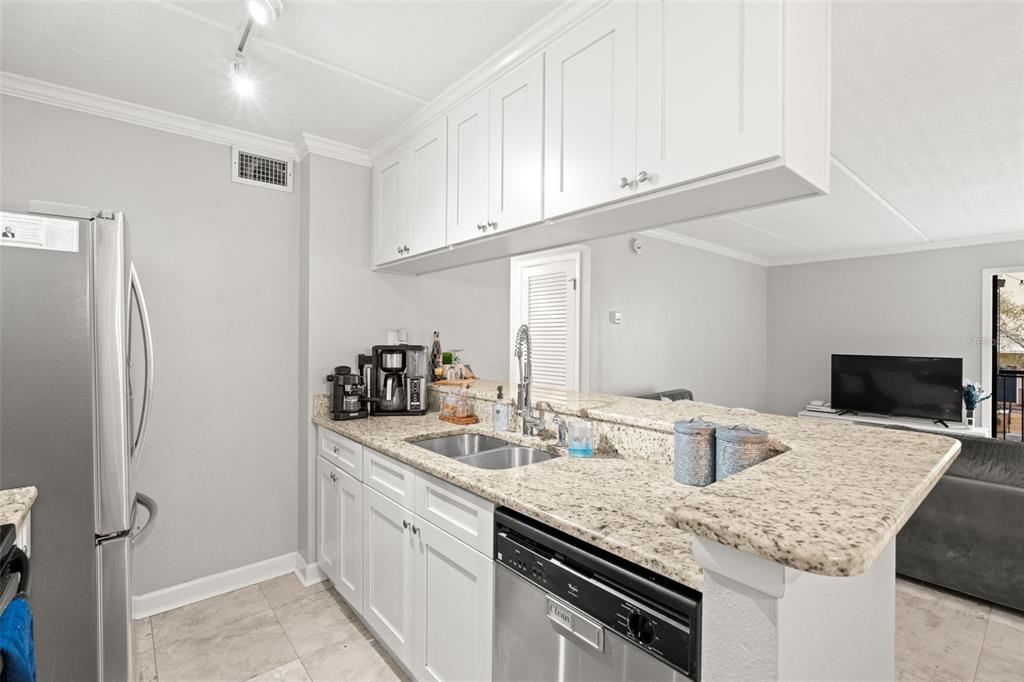 107 South Obrien Street, Unit 217 Tampa, FL 33609 - Photo 15 of 39 a kitchen with stainless steel appliances granite countertop a sink stove and refrigerator