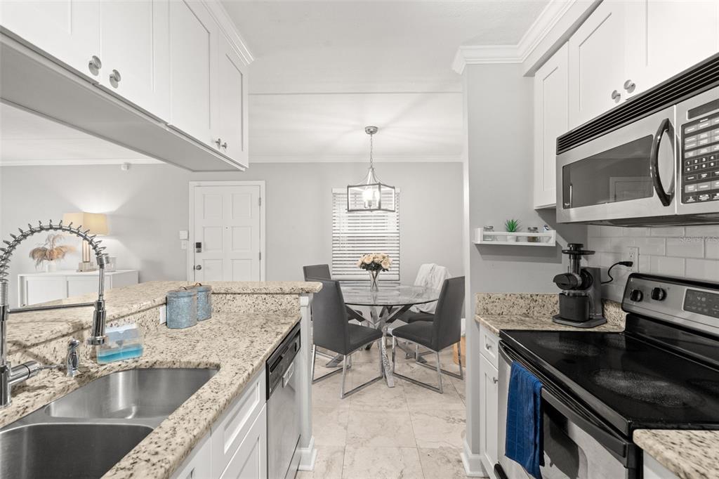 107 South Obrien Street, Unit 217 Tampa, FL 33609 - Photo 22 of 39 a kitchen with granite countertop a sink and stove