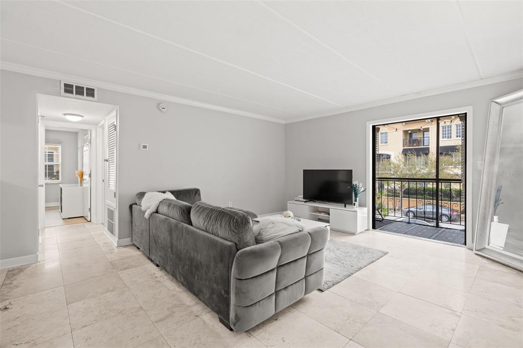 107 South Obrien Street, Unit 217 Tampa, FL 33609 - Photo 3 of 39 a living room with furniture and a flat screen tv