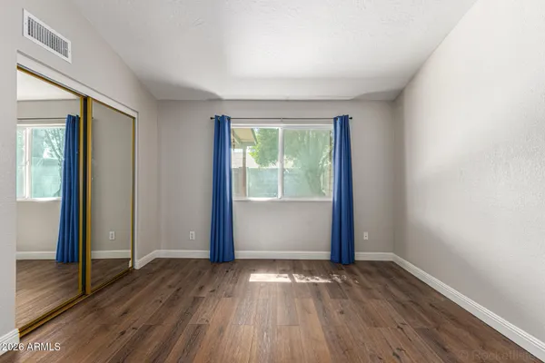 an empty room with wooden floor and windows