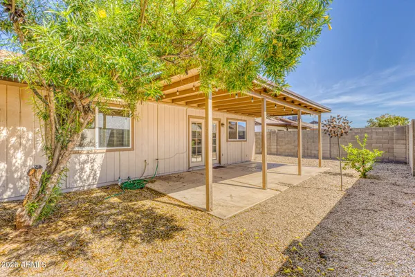 a backyard of a house with table and chairs