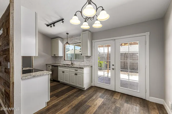 a kitchen with granite countertop a stove a sink and dishwasher wooden cabinets with wooden floor