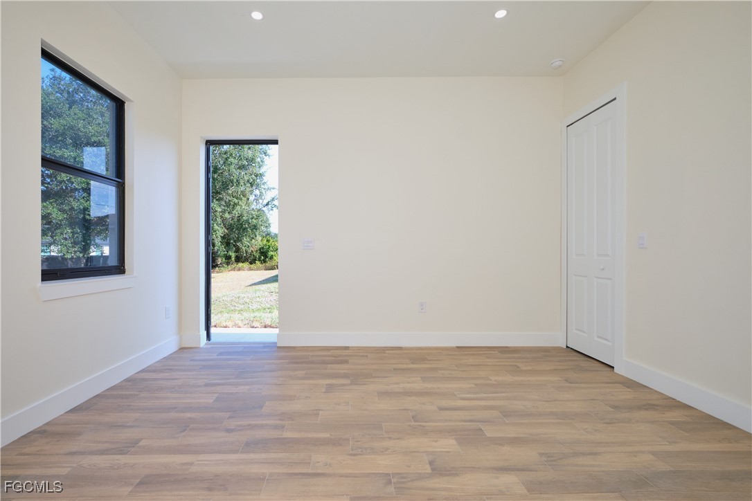 3804 6th Street Southwest Lehigh Acres, FL 33976 - Photo 31 of 45 a view of an empty room with wooden floor and a window
